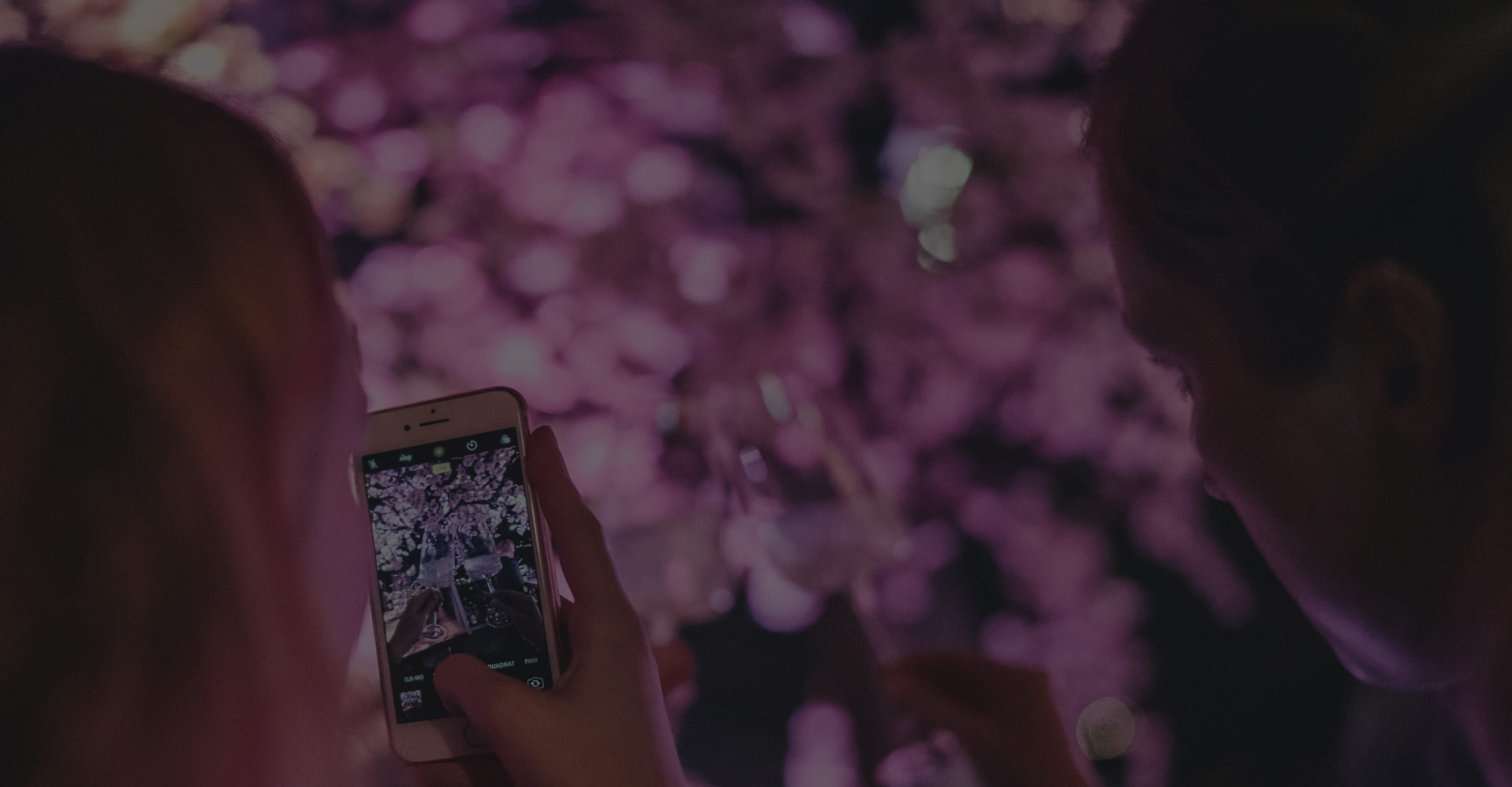 Detailansicht einer Frau mit Handy, die Bild einer Party macht